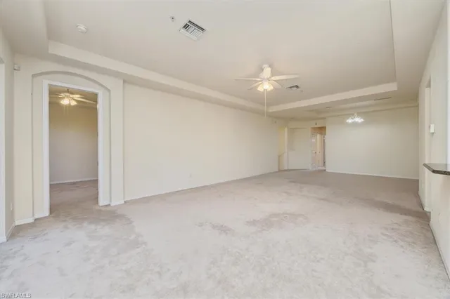 an empty room with a ceiling fan and a window