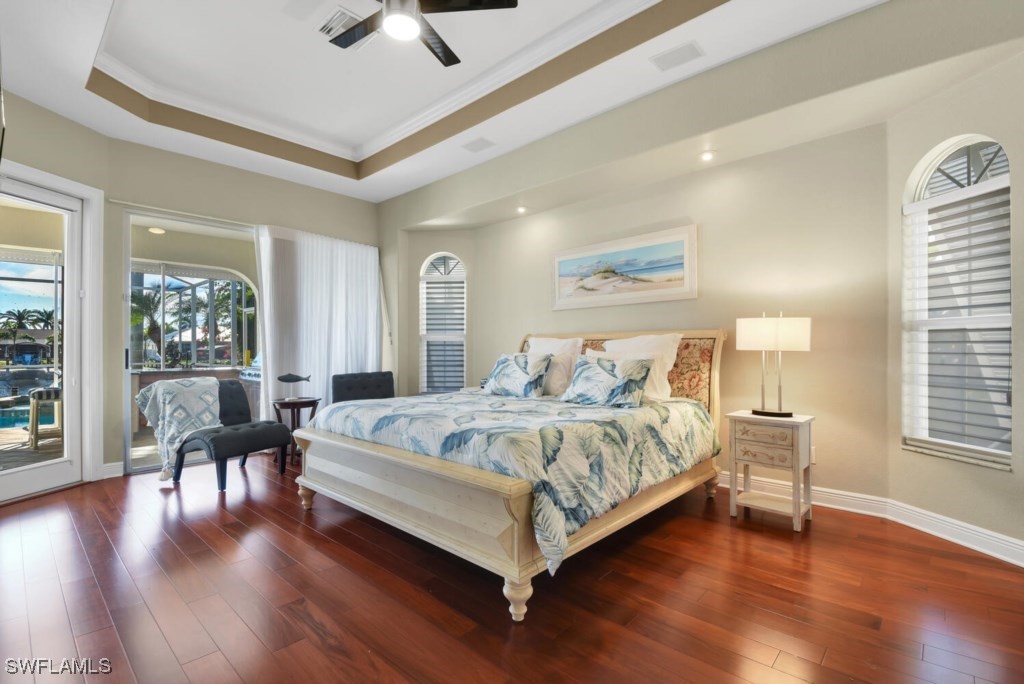 2810 Southwest 49th Terrace Cape Coral, FL 33914 - Photo 14 of 33 a bedroom with a large bed and a chandelier