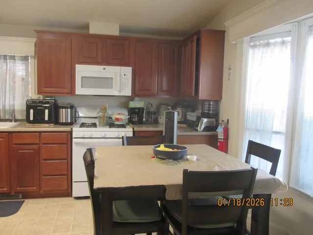 a kitchen with a dining table chairs and granite counter tops