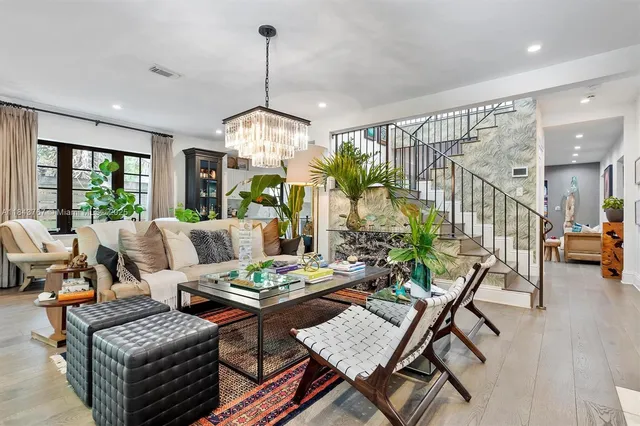 a dining room with furniture a chandelier and wooden floor