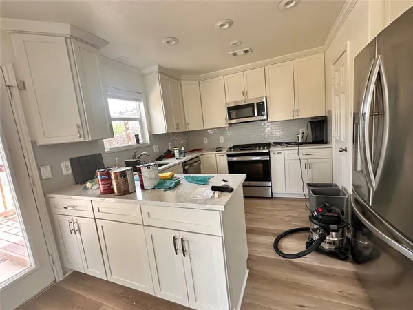 a kitchen with a sink white cabinets and white appliances