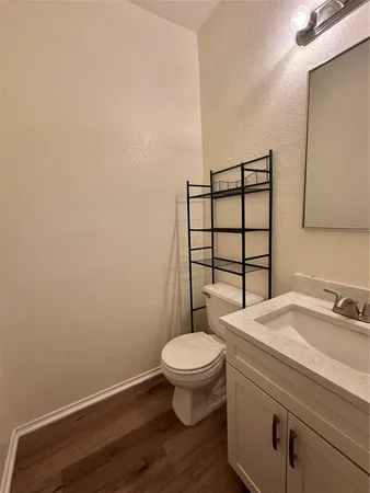 a bathroom with a granite countertop toilet and a sink
