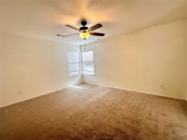 an empty room with a window and a ceiling fan