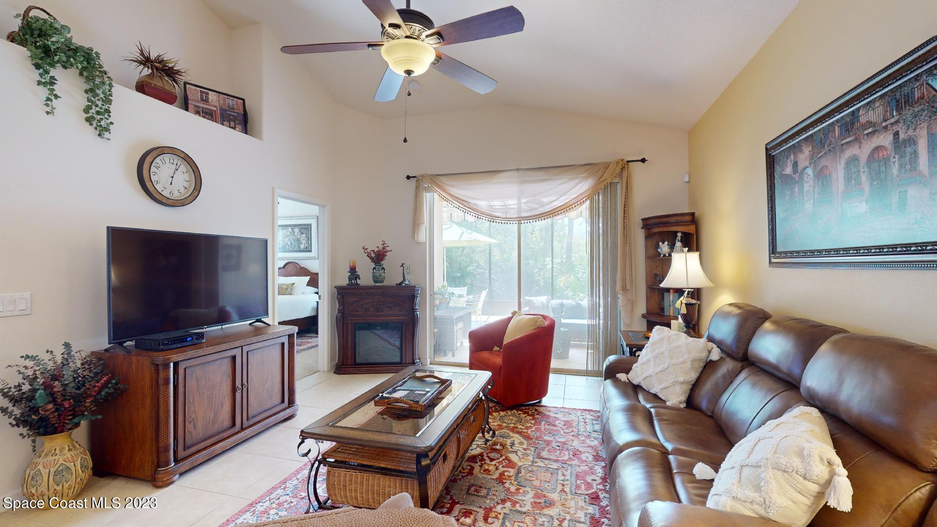 3242 Arden Circle Melbourne, FL 32934 - Photo 12 of 28 a living room with furniture a flat screen tv and a large window