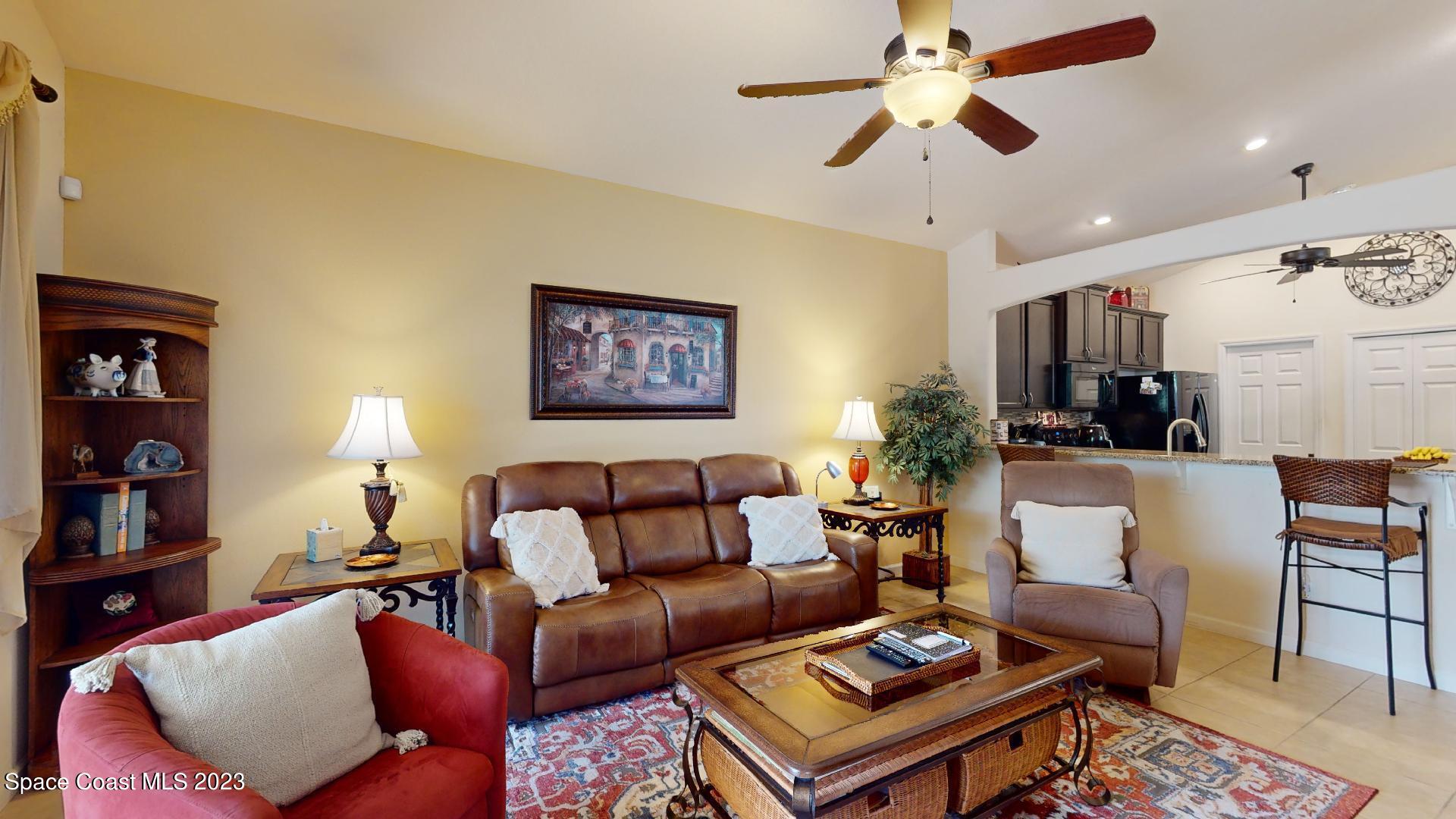 3242 Arden Circle Melbourne, FL 32934 - Photo 14 of 28 a living room with furniture a lamp and a chandelier