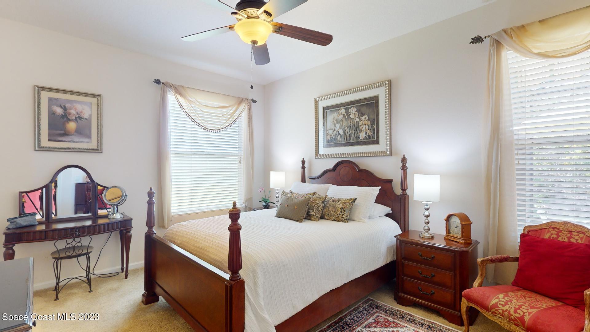 3242 Arden Circle Melbourne, FL 32934 - Photo 16 of 28 a bedroom with a bed and a chandelier