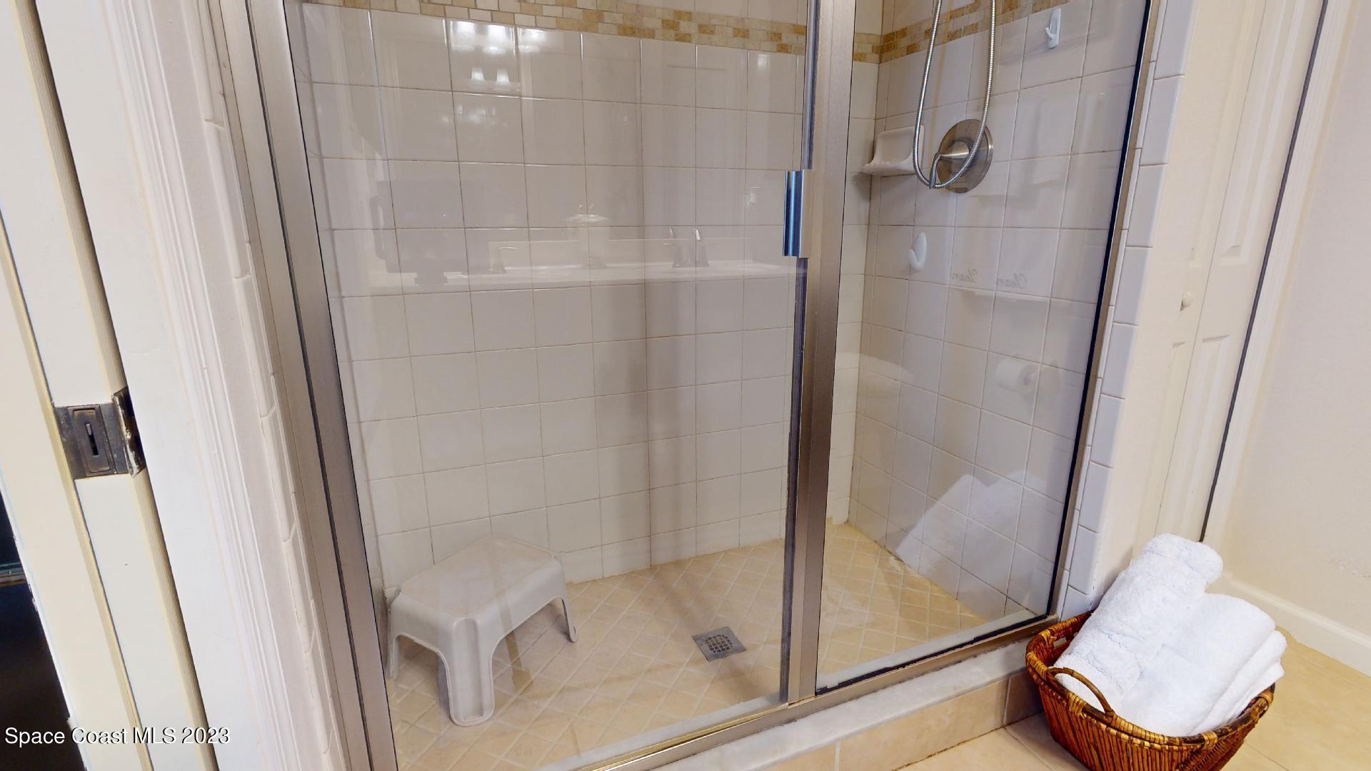 3242 Arden Circle Melbourne, FL 32934 - Photo 19 of 28 a bathroom with a glass shower door