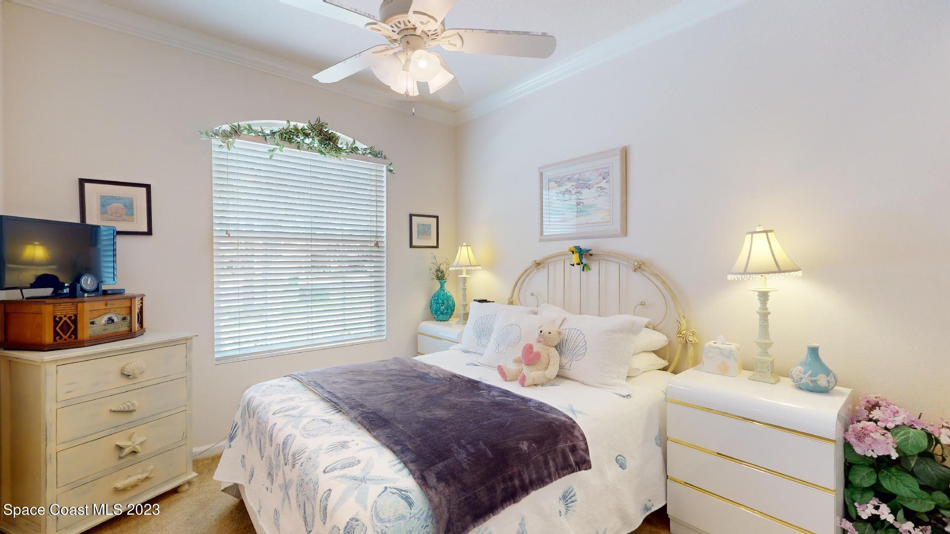 3242 Arden Circle Melbourne, FL 32934 - Photo 20 of 28 a bedroom with a bed and a chandelier