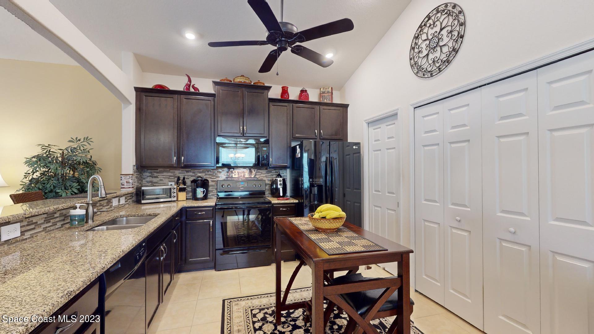 3242 Arden Circle Melbourne, FL 32934 - Photo 8 of 28 a kitchen with sink cabinets and outdoor space