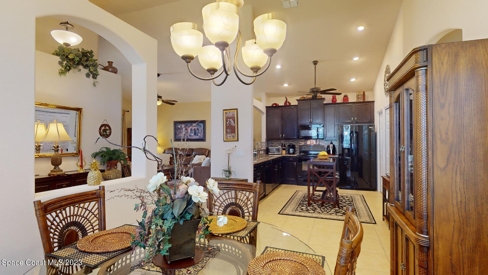 3242 Arden Circle Melbourne, FL 32934 - Photo 9 of 28 a very nice looking dining room with a table chairs and a chandelier