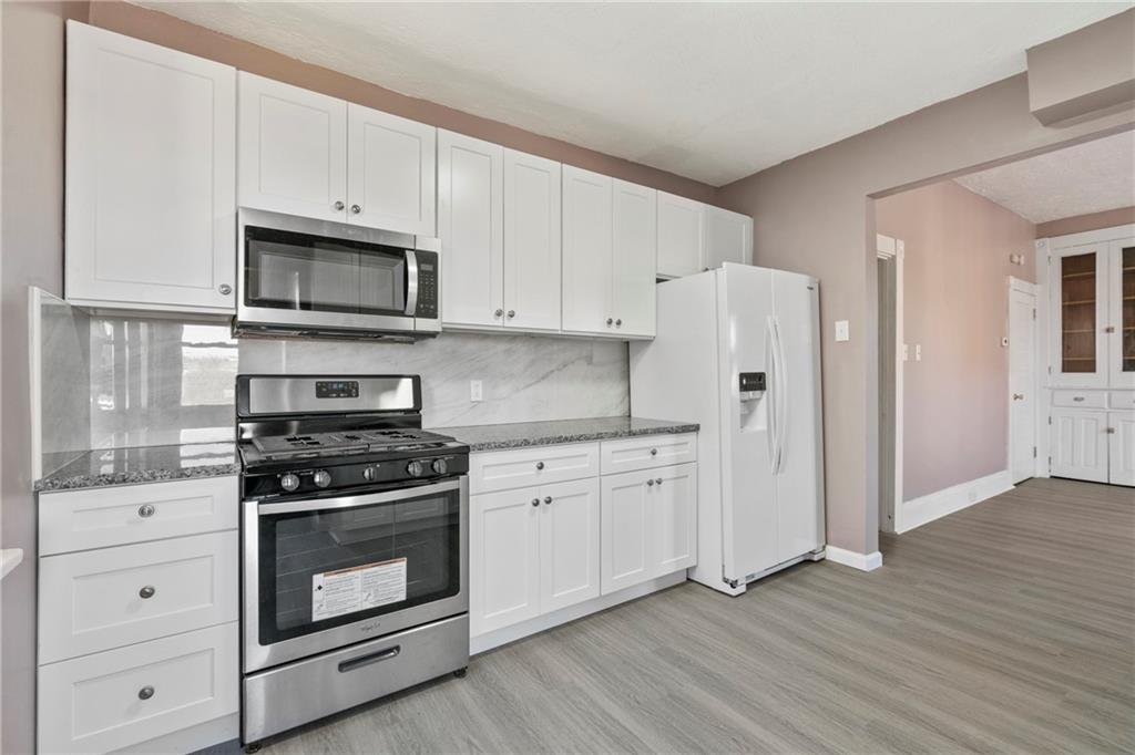 711 9th Avenue Irwin, PA 15642 - Photo 13 of 26 a kitchen with cabinets stainless steel appliances and wooden floor