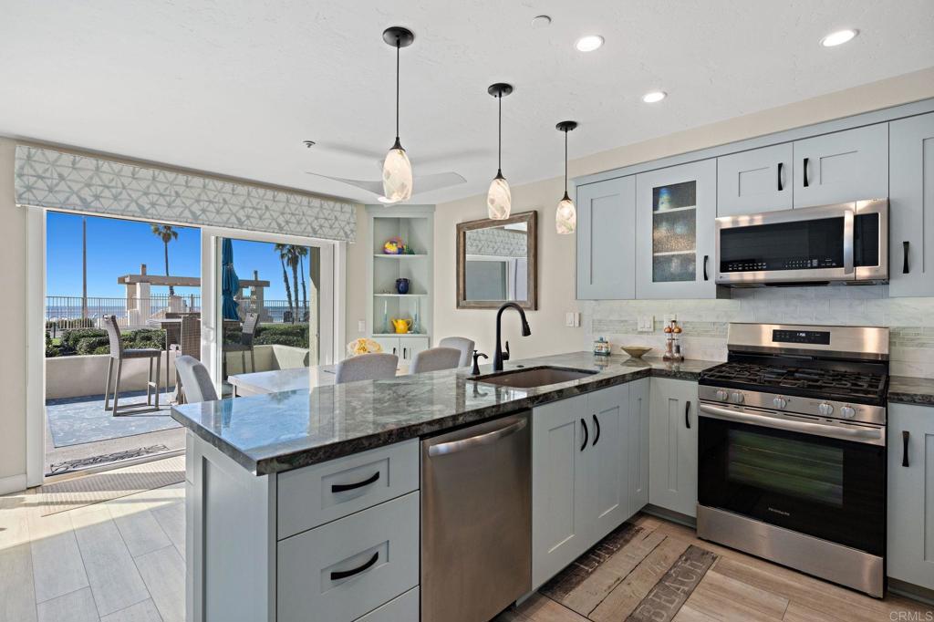 a kitchen with stainless steel appliances granite countertop a stove a sink and a microwave