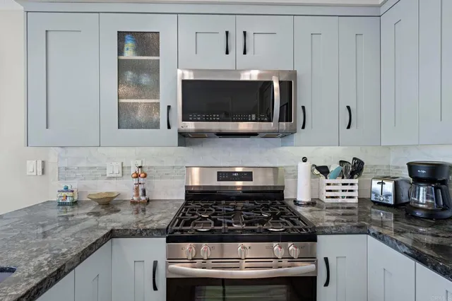 a kitchen with stainless steel appliances granite countertop a stove and a microwave