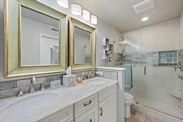 a bathroom with a granite countertop sink a toilet and a mirror