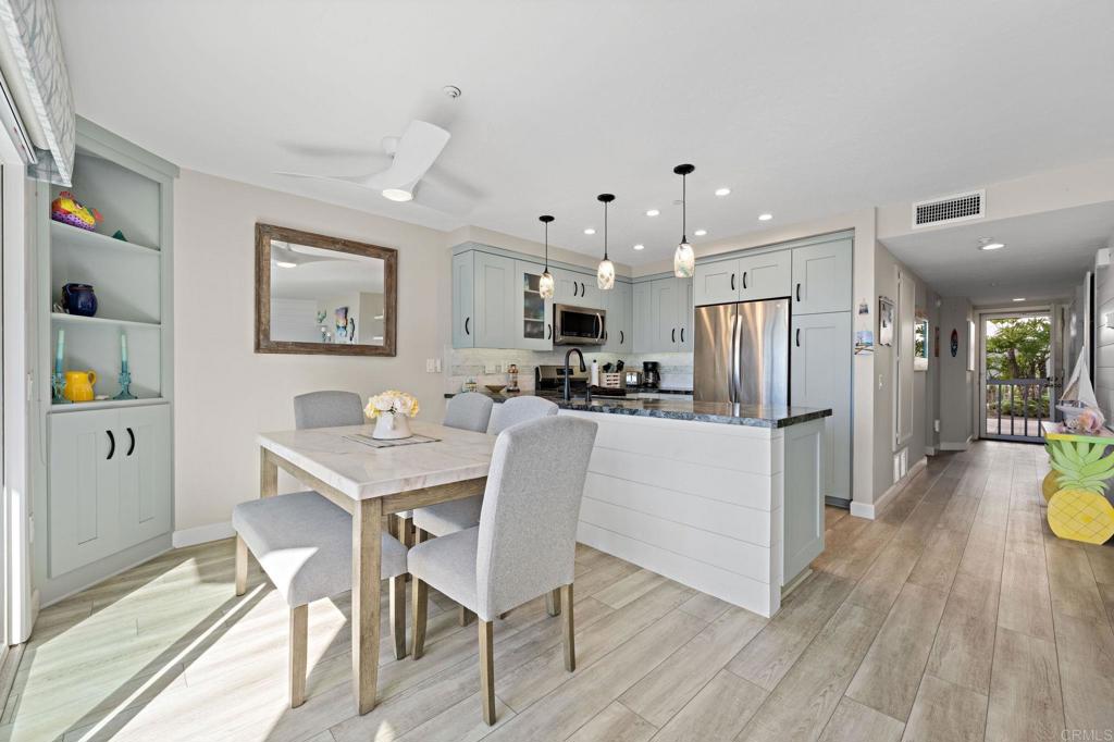 600 The Strand North, Unit 25 Oceanside, CA 92054 - Photo 8 of 25 a kitchen with stainless steel appliances a dining table chairs and refrigerator