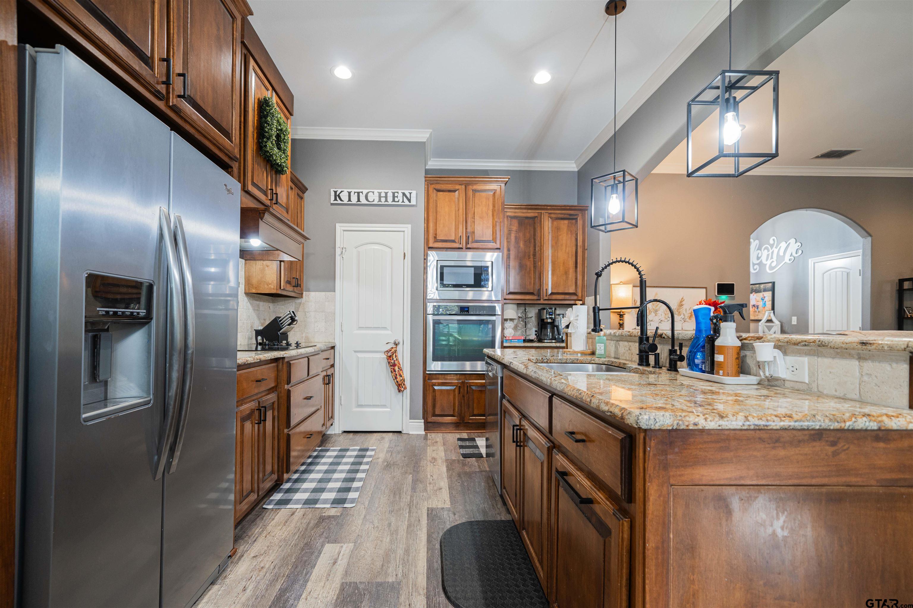 1001 Millstone Lane Chandler, TX 75758 - Photo 9 of 30 a kitchen with stainless steel appliances granite countertop a sink a stove and a refrigerator