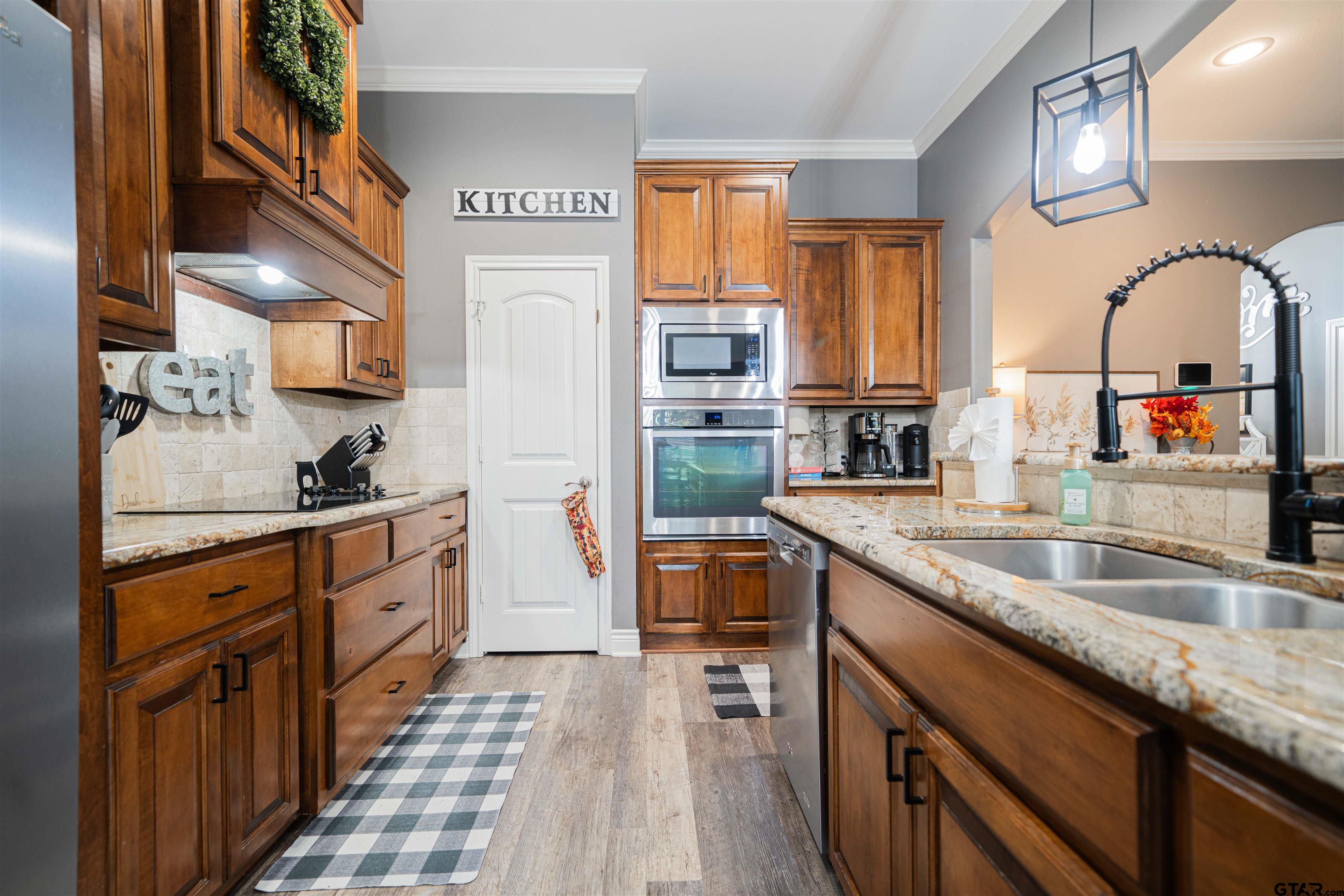 1001 Millstone Lane Chandler, TX 75758 - Photo 10 of 30 a kitchen with stainless steel appliances granite countertop lots of counter top space and wooden floor