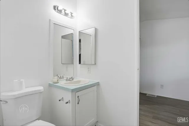 a bathroom with a sink toilet and mirror