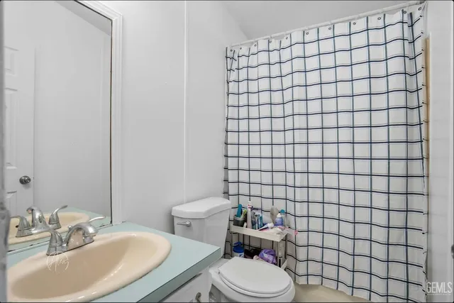 a bathroom with a sink a toilet and mirror