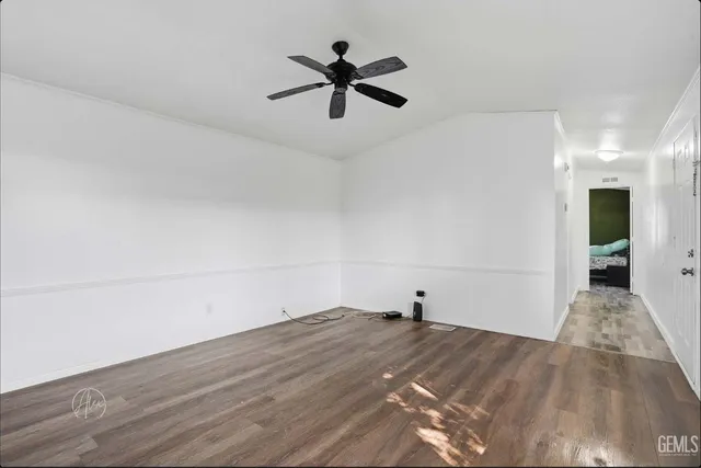 a view of a room with wooden floor and ceiling fan