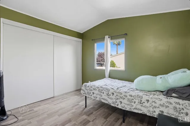 a bedroom with a bed and wooden floor