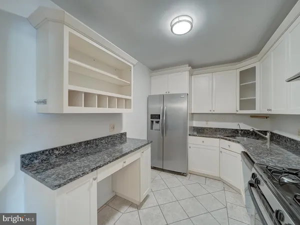 a kitchen with granite countertop a stove sink and cabinets