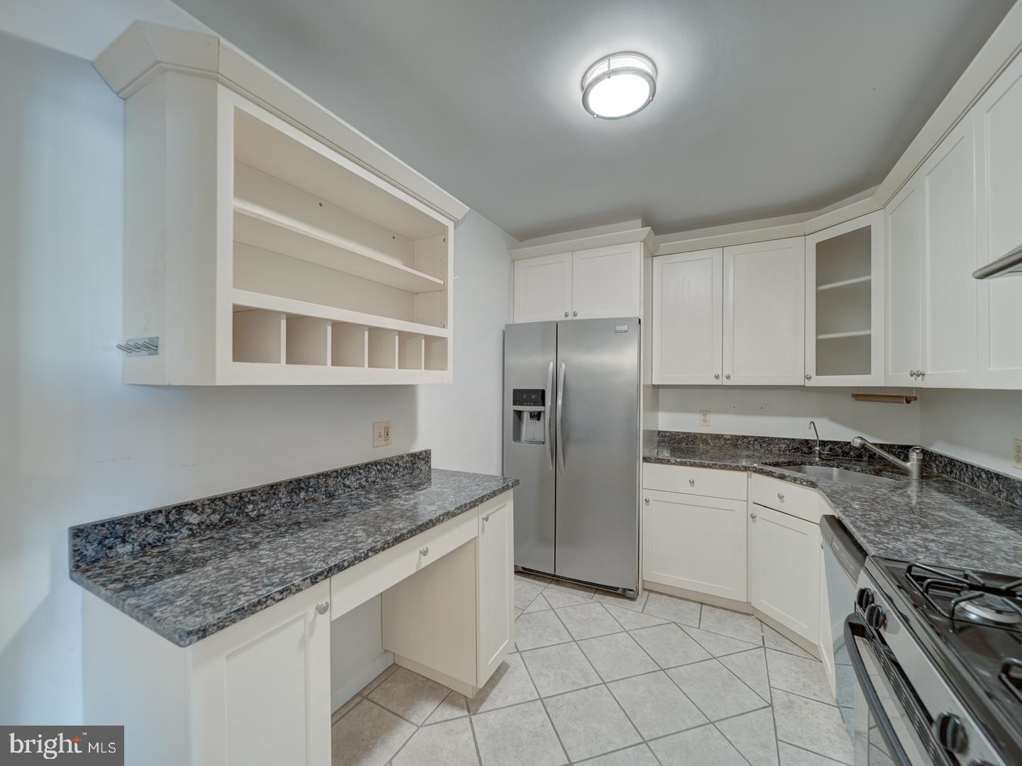 5101 River Road, Unit 411 Bethesda, MD 20816 - Photo 15 of 26 a kitchen with granite countertop a sink stove and refrigerator