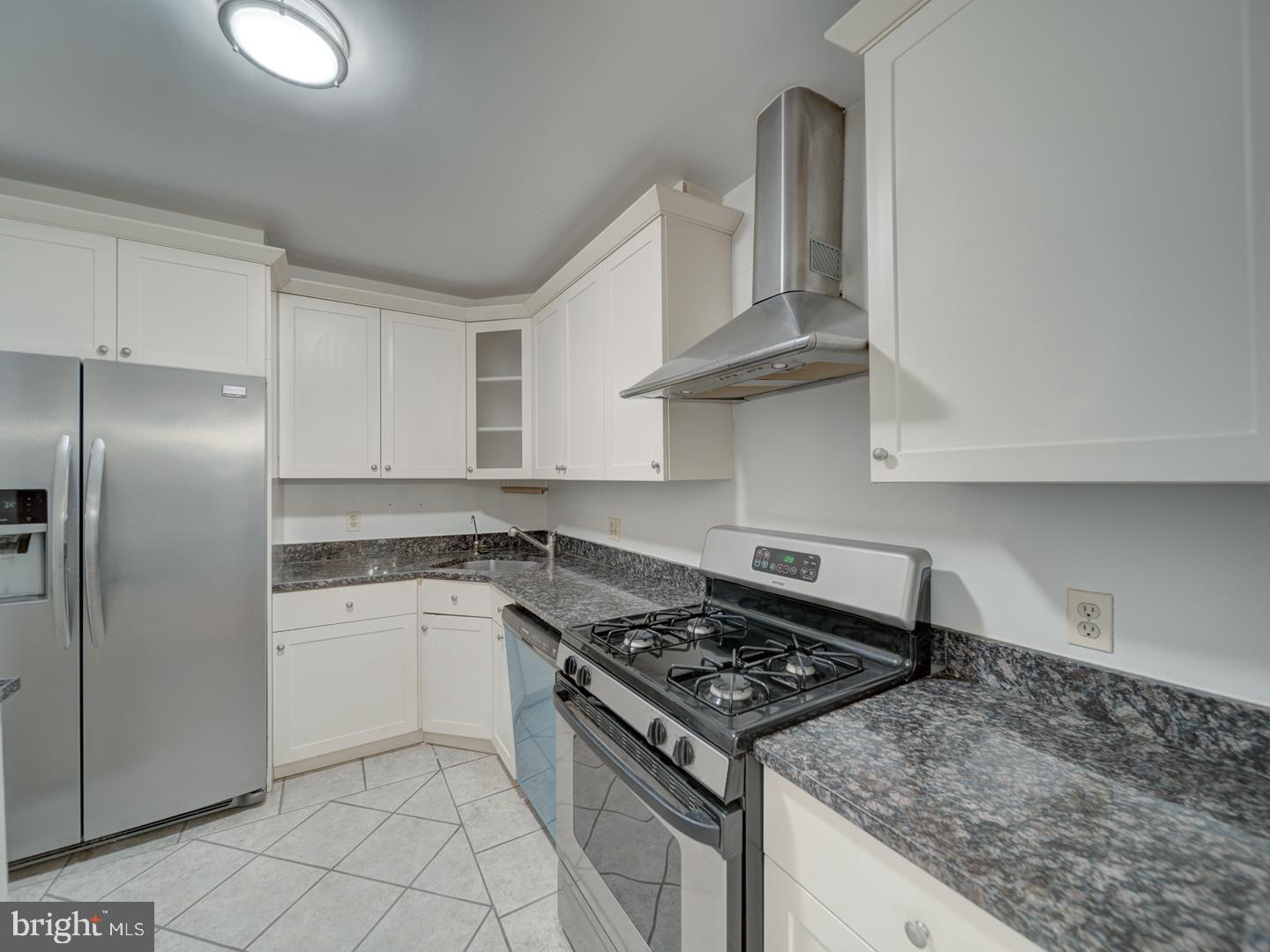 5101 River Road, Unit 411 Bethesda, MD 20816 - Photo 16 of 26 a kitchen with granite countertop a stove sink and cabinets