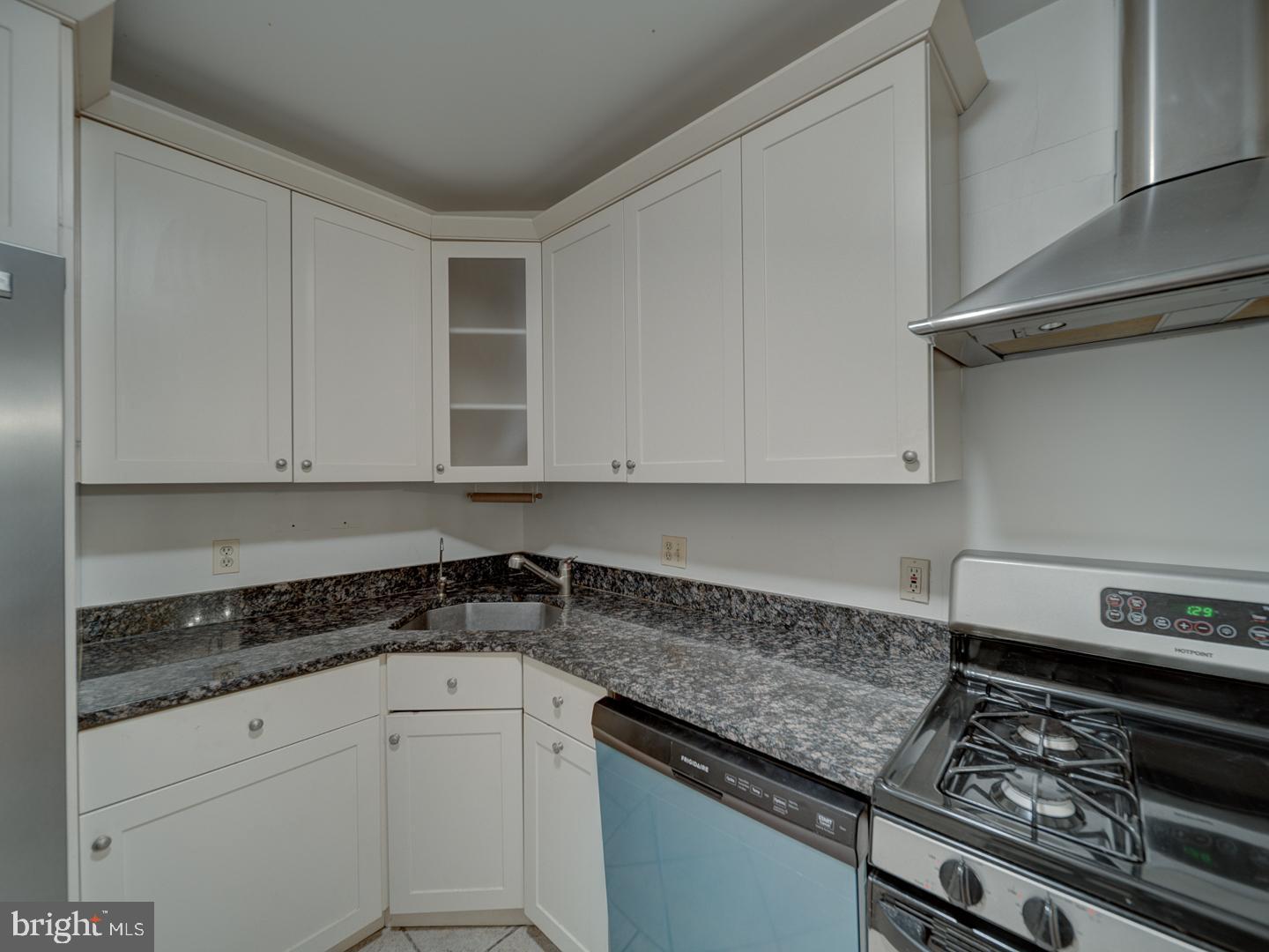 5101 River Road, Unit 411 Bethesda, MD 20816 - Photo 18 of 26 a kitchen with granite countertop white cabinets and a stove top oven