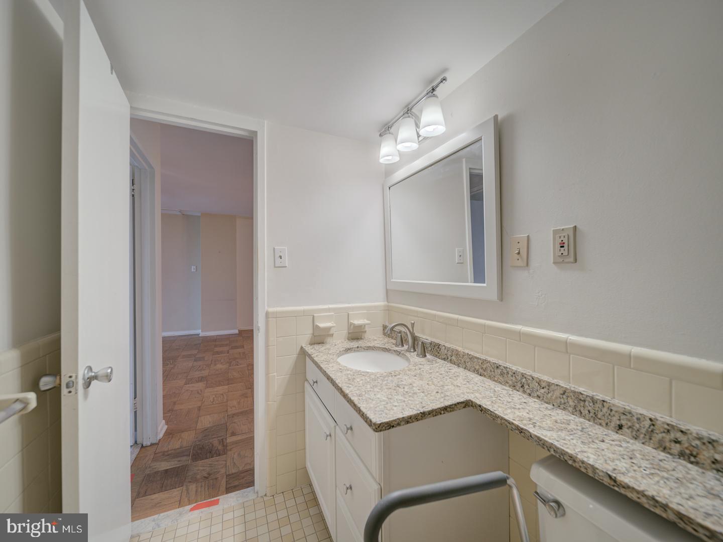 5101 River Road, Unit 411 Bethesda, MD 20816 - Photo 21 of 26 a bathroom with a granite countertop sink and a mirror