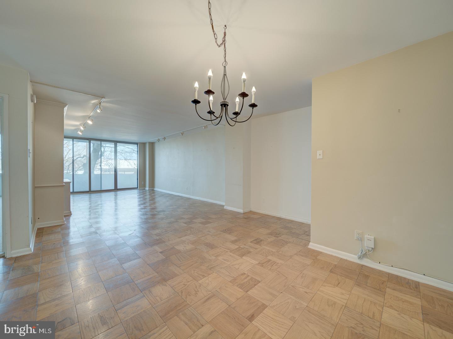 5101 River Road, Unit 411 Bethesda, MD 20816 - Photo 7 of 26 a view of an empty room with chandelier and wooden floor