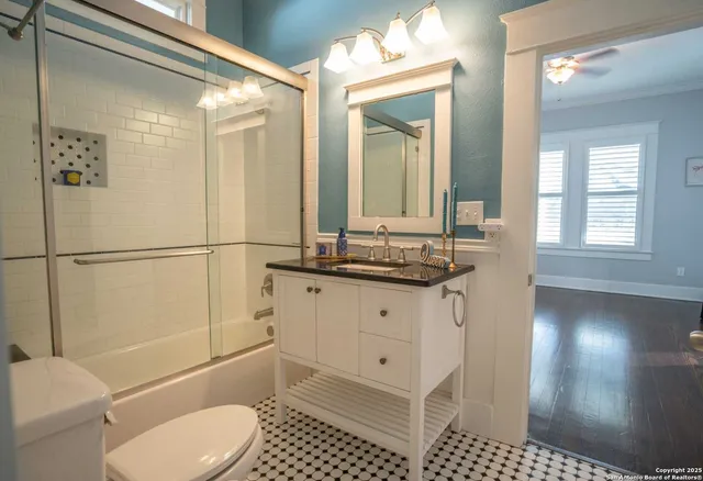 a bathroom with a sink a toilet and shower