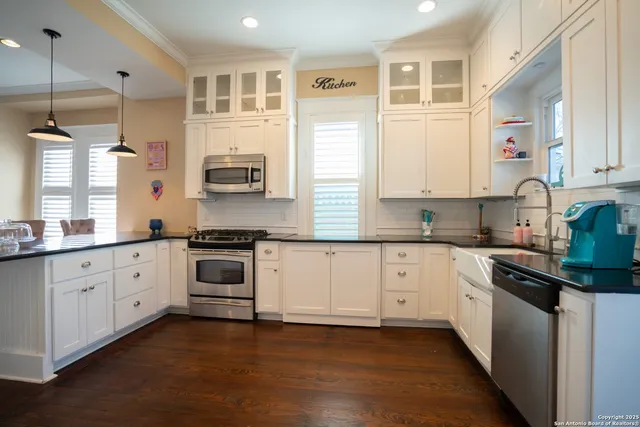 a kitchen with granite countertop white cabinets and white appliances
