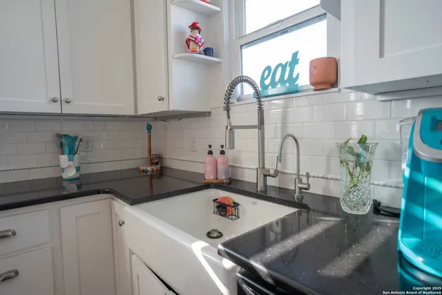 a kitchen with a stove a sink and cabinets