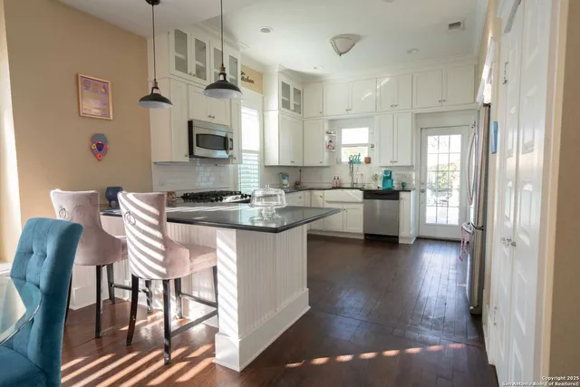 a kitchen with a table chairs and a refrigerator