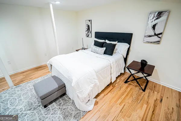 a bedroom with a bed and wooden floor