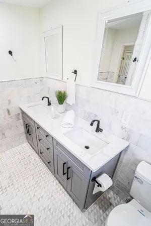 a spacious bathroom with a double vanity sink mirror and toilet