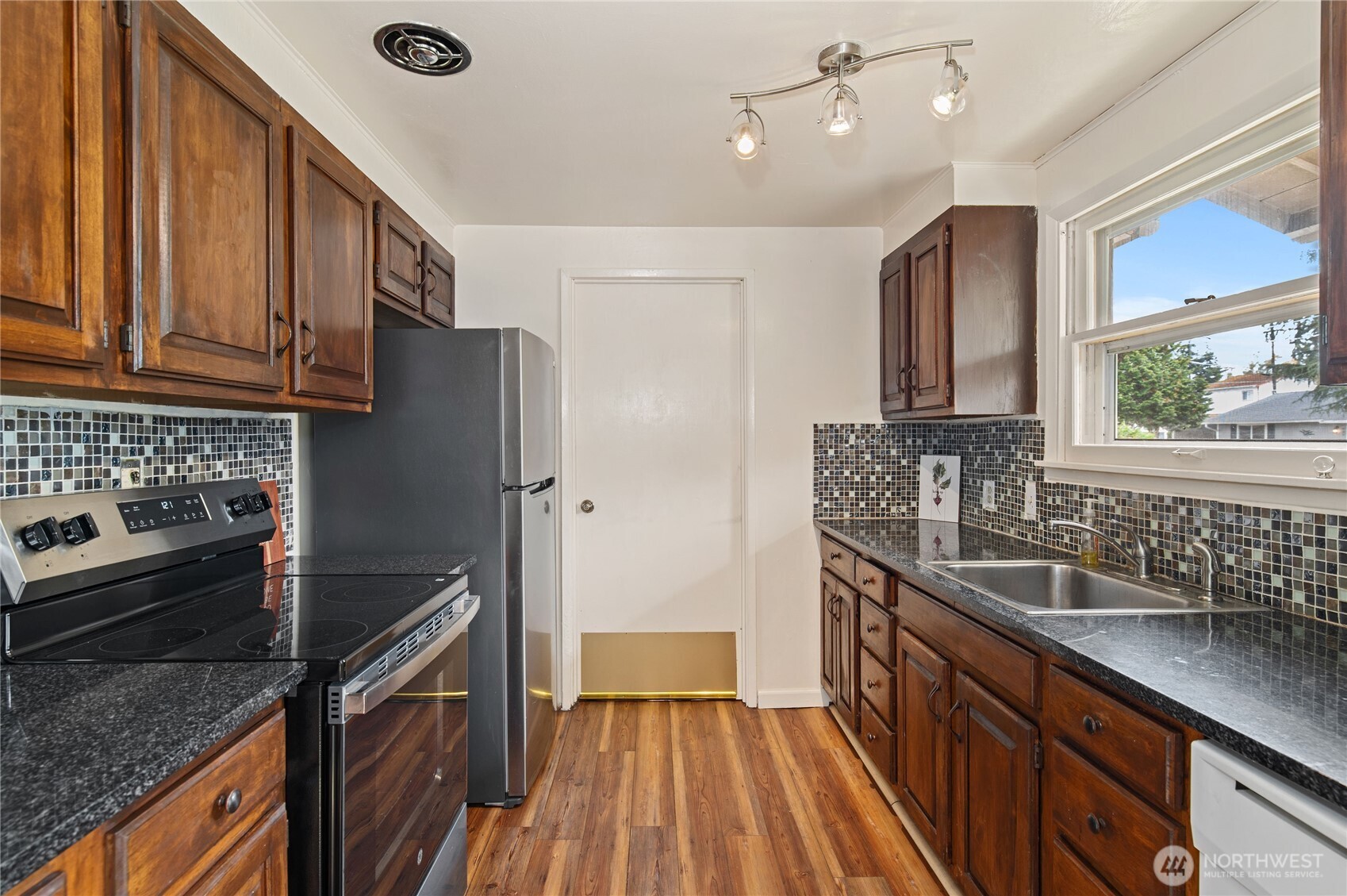 944 East 30th Street Bremerton, WA 98310 - Photo 7 of 21 a kitchen with granite countertop a sink stainless steel appliances a counter space and cabinets