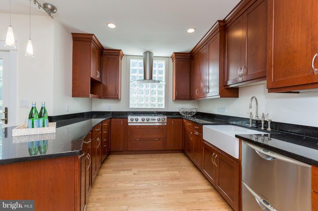 a kitchen with stainless steel appliances granite countertop wooden cabinets a stove top oven a sink and dishwasher