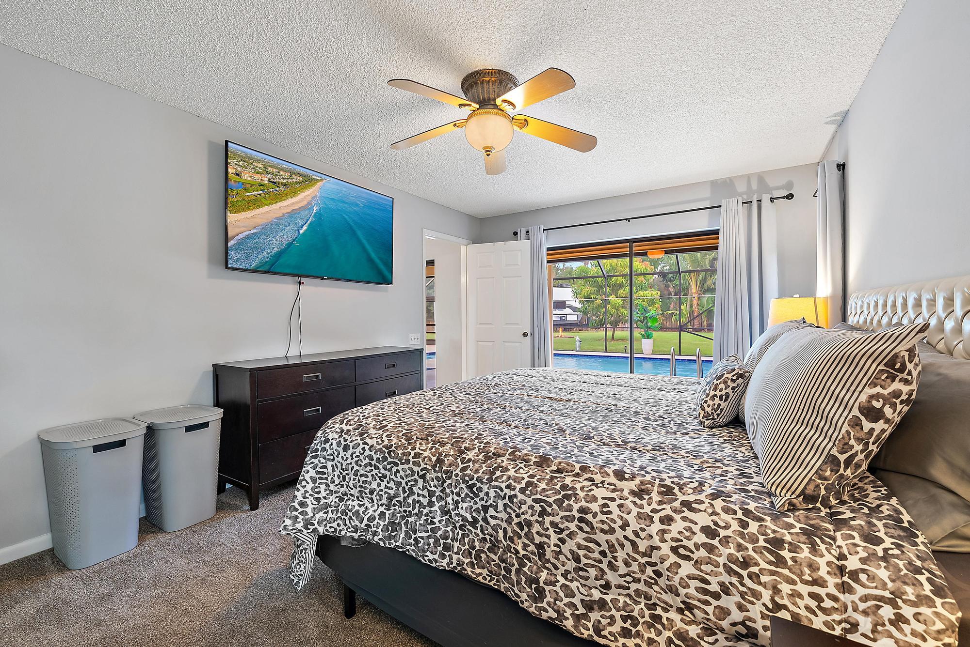 126 Coco Lane Jupiter, FL 33458 - Photo 15 of 40 a bedroom with a bed and a chandelier