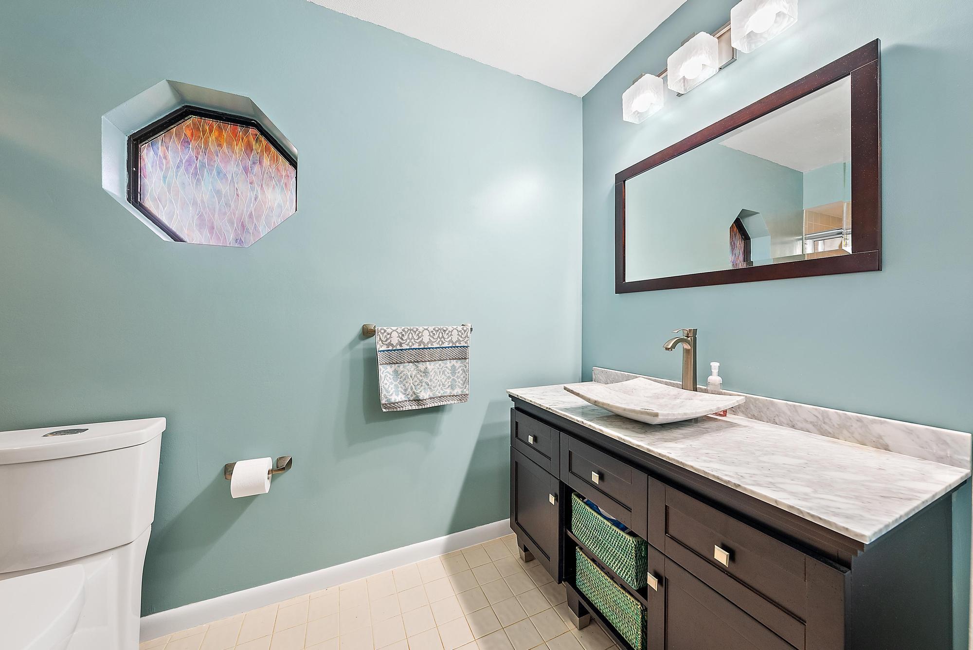 126 Coco Lane Jupiter, FL 33458 - Photo 17 of 40 a bathroom with a sink a mirror and a toilet