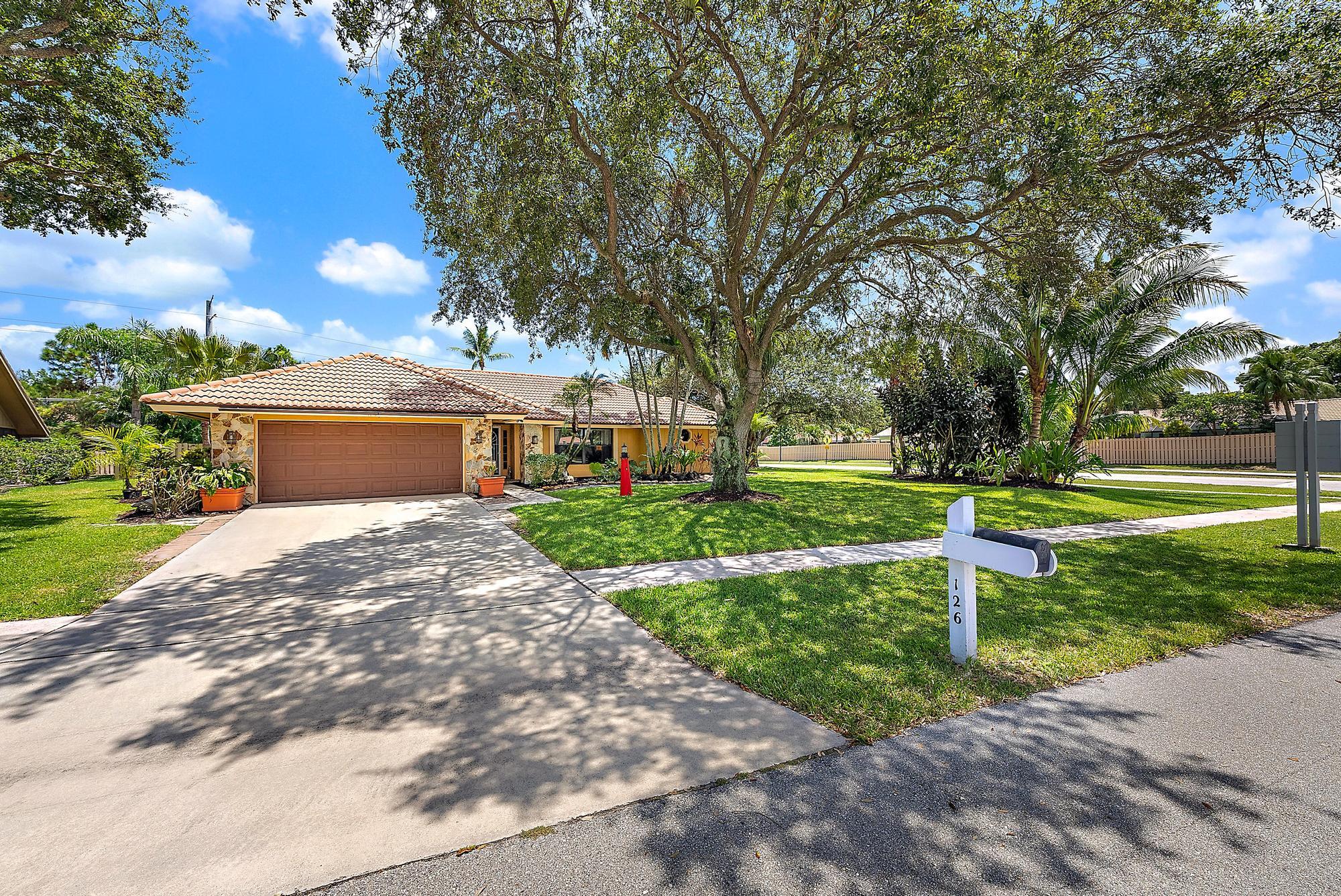 126 Coco Lane Jupiter, FL 33458 - Photo 29 of 40 a front view of a house with a yard and a garden