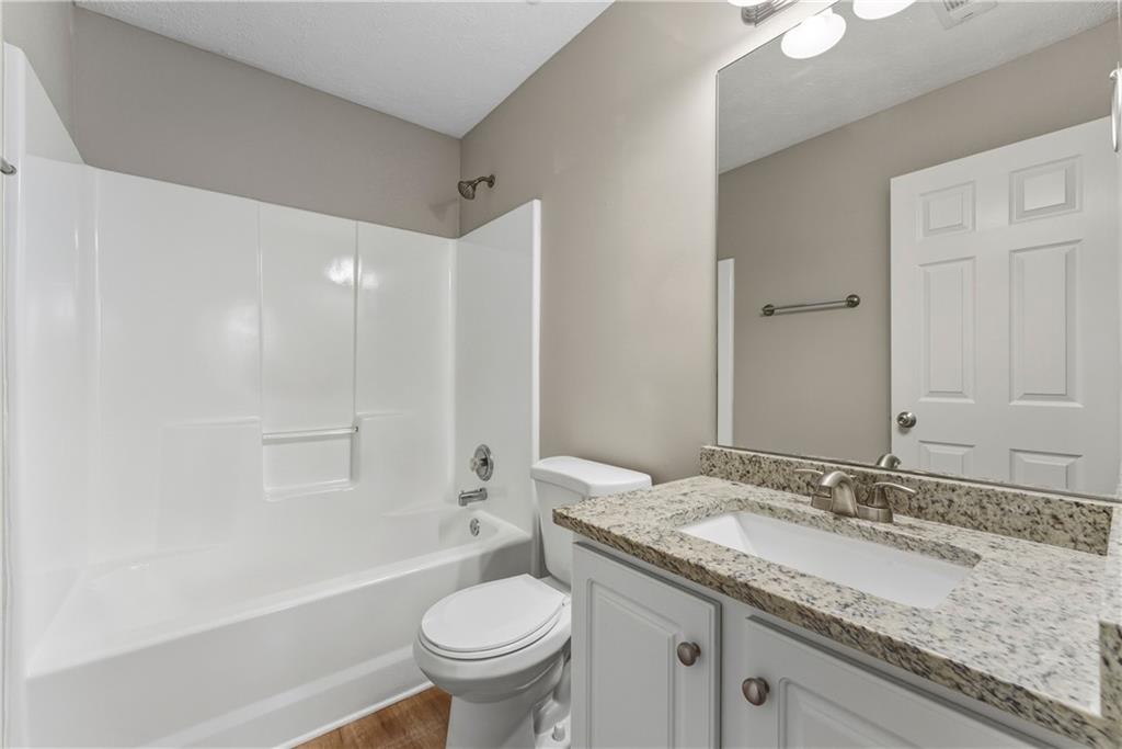7570 Old Field Cove Road Cumming, GA 30028 - Photo 11 of 18 a bathroom with a granite countertop sink toilet and shower
