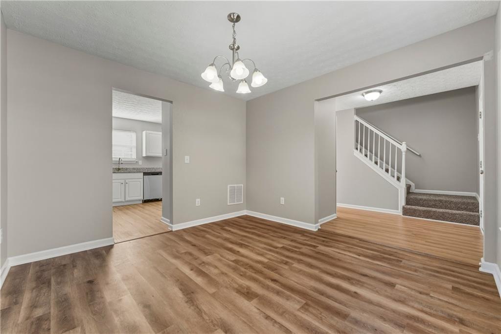 7570 Old Field Cove Road Cumming, GA 30028 - Photo 3 of 18 a view of an empty room with wooden floor and staircase