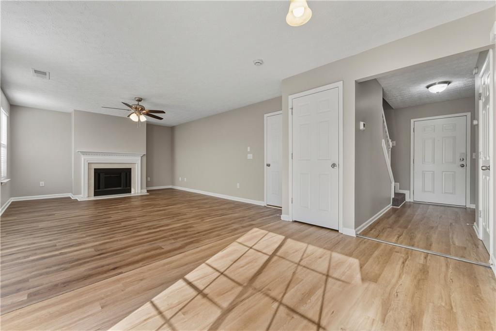 7570 Old Field Cove Road Cumming, GA 30028 - Photo 8 of 18 a view of empty room with wooden floor and fireplace