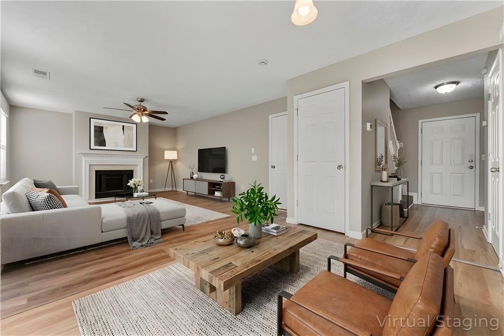 7570 Old Field Cove Road Cumming, GA 30028 - Photo 9 of 18 a living room with furniture a fireplace and a flat screen tv