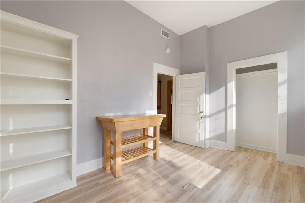3210 Hampton Road, Unit A B C Austin, TX 78705 - Photo 27 of 42 Light wood-finish flooring with built-in shelving, white trim, and a recessed clothing storage area