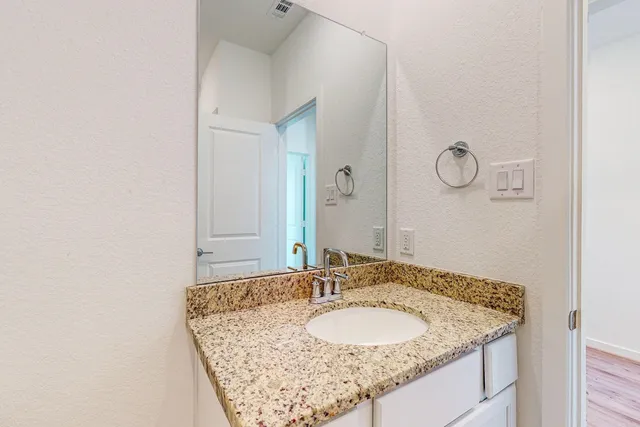 a bathroom with a granite countertop sink and a mirror