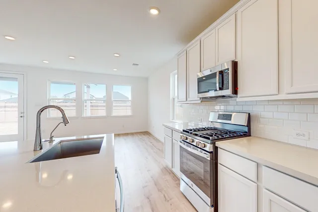 a kitchen with granite countertop a sink stainless steel appliances and cabinets
