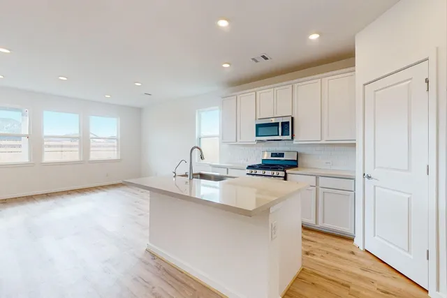 a kitchen with granite countertop white cabinets and stainless steel appliances